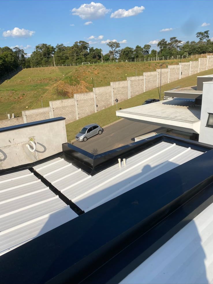 Rufo preto e telhado trapezoidal branco em obra de alto padrão em Campinas
